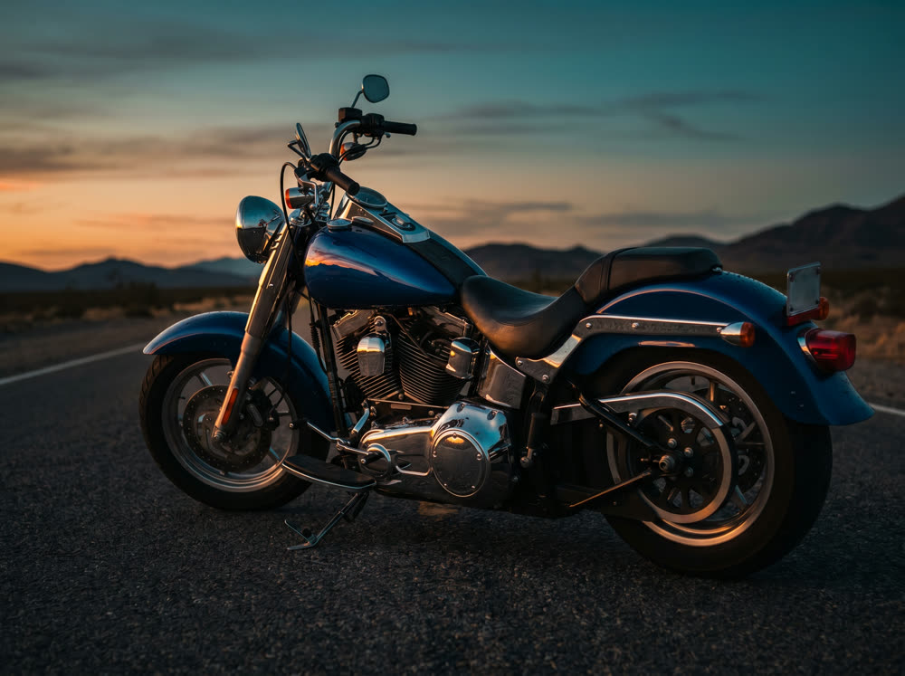 Cruiser motorcycle parked on a desert road at sunset
