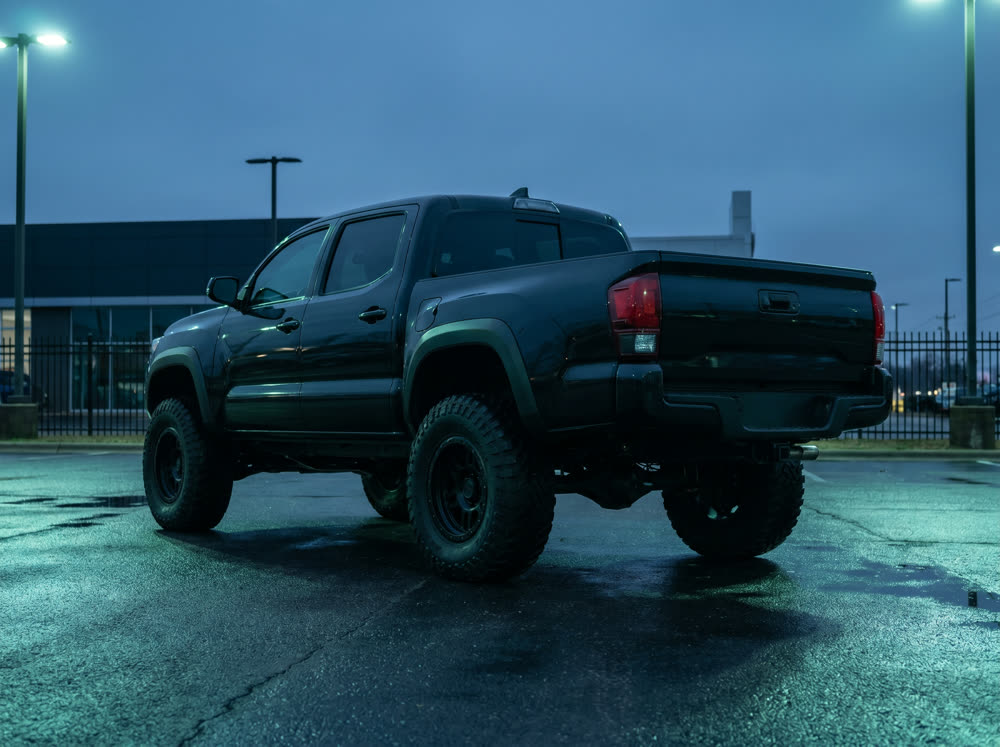 Lifted pickup truck rear three-quarter view during blue hour